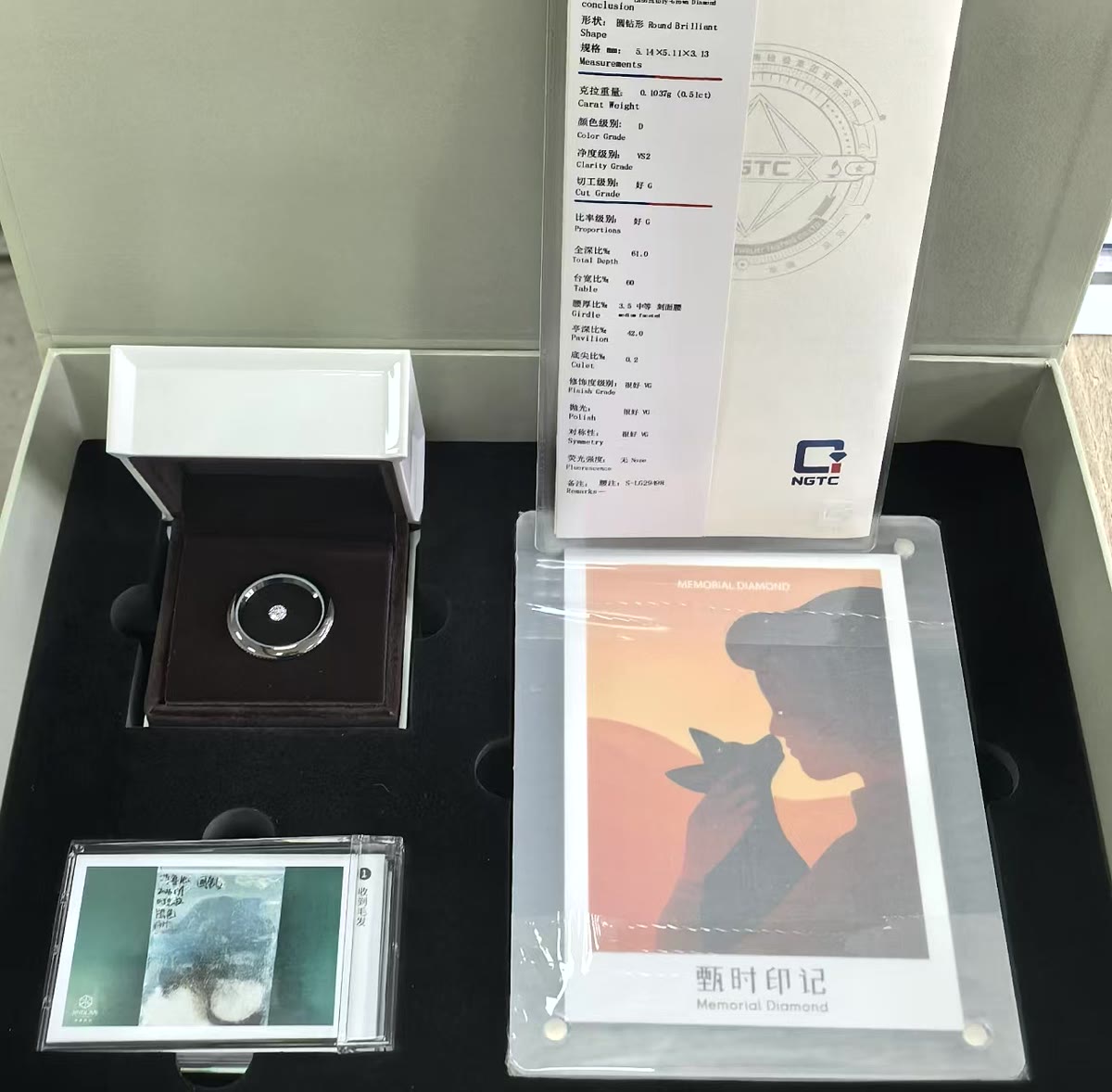 The presentation case: ring box, grading certificate, and a memorial keepsake booklet